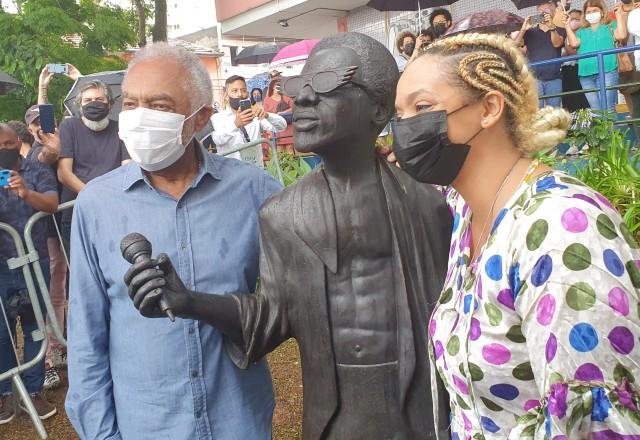 Gilberto Gil ao lado da estátua de Itamar Assumpção e da filha do cantor, Anelis