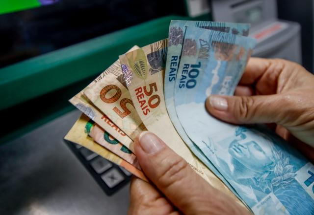 Pessoa segura cédulas de real | Divulgação/Governo