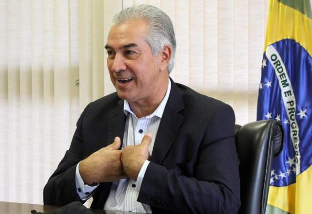 Reinaldo Azambuja à frente da bandeira do Brasil (Divulgação/Governo do MS)