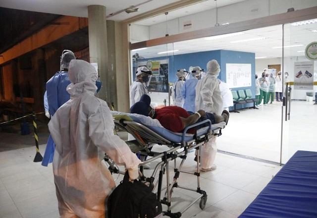 Profissionais da saúde carregam paciente deitado em maca, em direção à entrada de um hospital (Divulgação/Governo federal)
