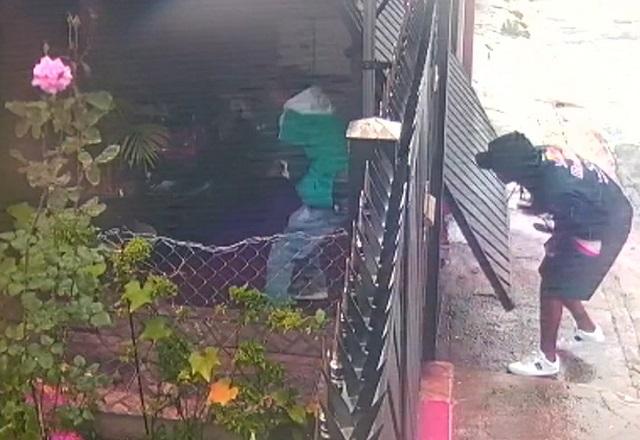 Grupo de homens invadindo garagem de residência pelo portão