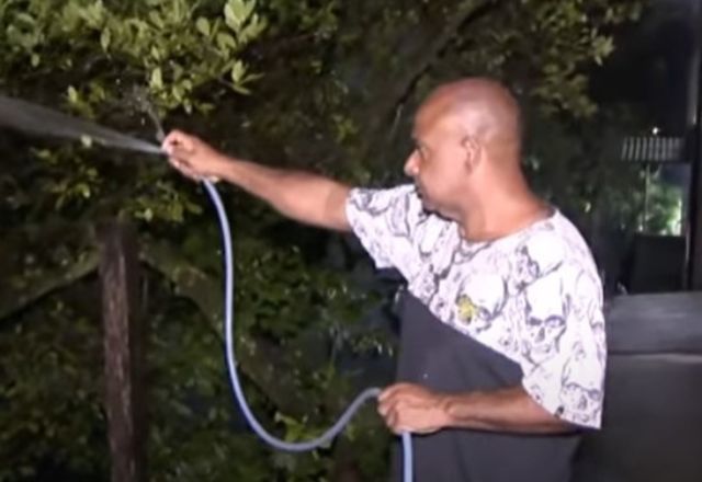 Zelador da instituição, Valdemir dos Santos, tenta evitar que fogo chegue à escola | Reprodução/SBT