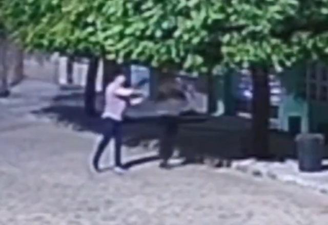 Homem atirando em outro, no meio da rua, durante a noite
