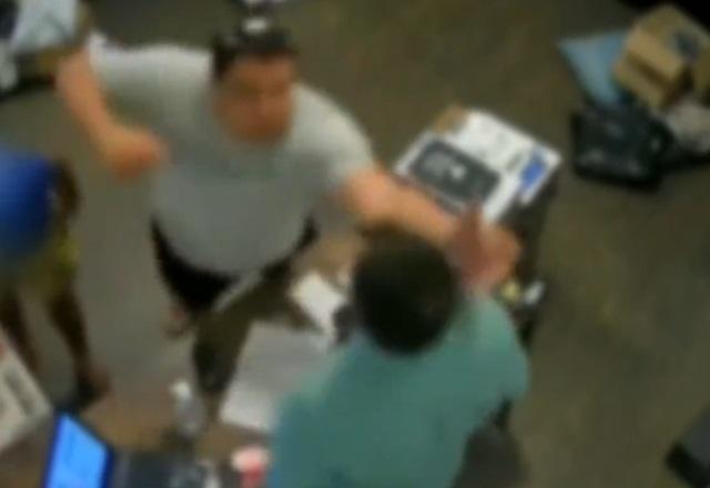 Homem branco dando soco em porteiro, dentro de portaria