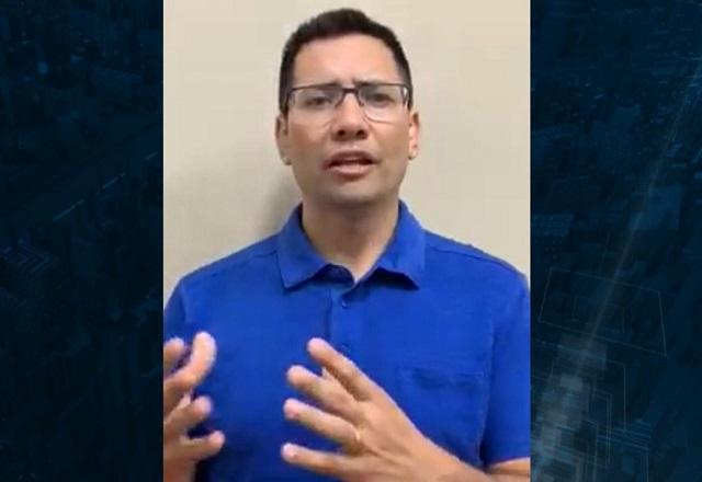 Homem branco de camiseta azul e óculos