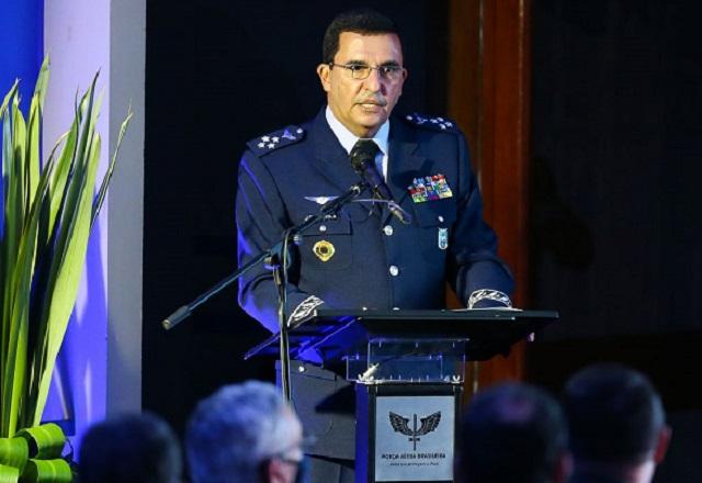 Homem branco, de farda azul com várias insígnias presas à roupa, em frente a púlpito durante discurso