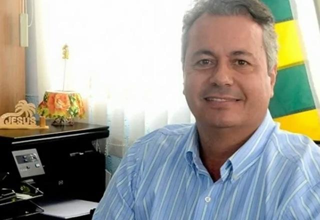 Homem branco sentado e sorrindo para foto