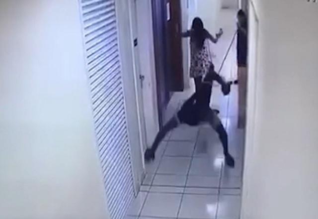 Homem caindo, em corredor de prédio, ao ser atingido por disparo de bala
