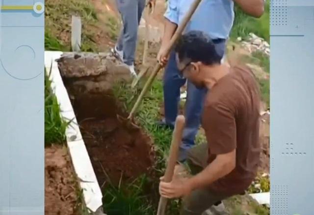 Homem cavando cova em cemitério