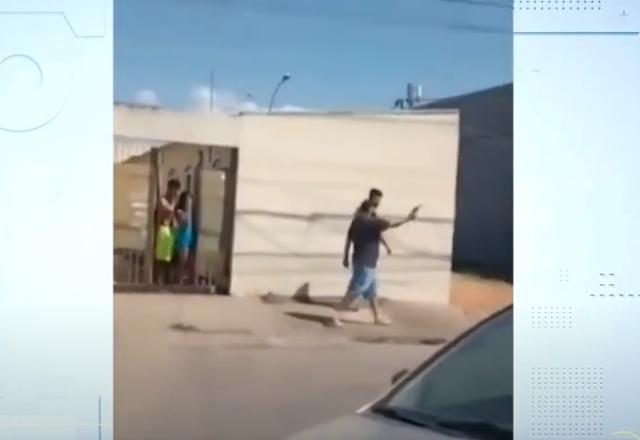Homem de boné andando armado em uma rua