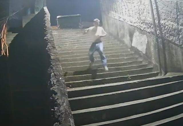 Homem de camisa branca descendo escada de uma viela