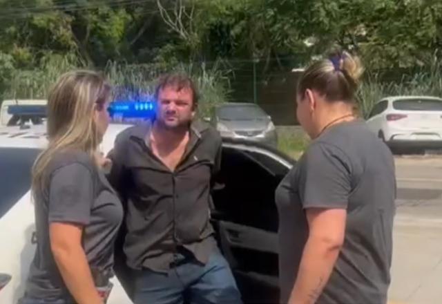 Homem de camisa preta sendo preso