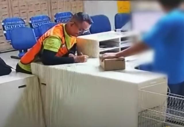 Homem de colete laranja escrevendo em um papel