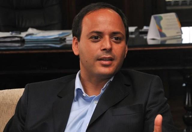 Homem de paletó preto e camisa azul