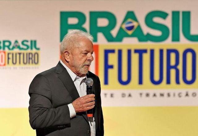 Homem de terno, barba e cabelos brancos falando ao microfone