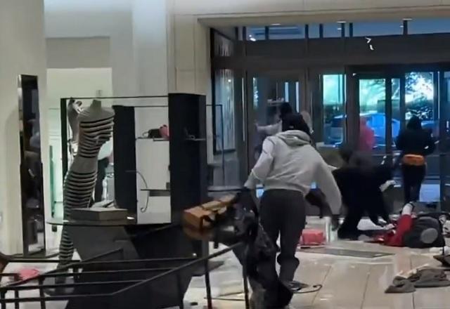 Homem mascarado correndo no interior de loja de luxo