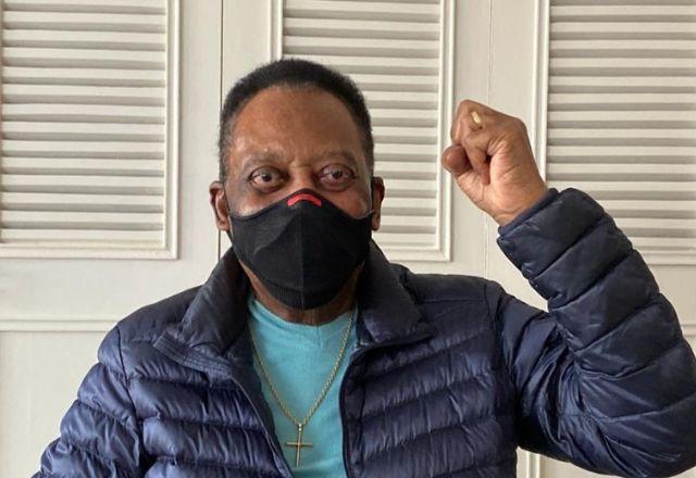 Homem negro, com máscara no rosto e roupas escuras. Este é Pelé.