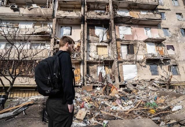 Homem olha destroços de edifício atingido por bombardeio na Ucrânia