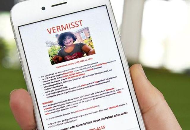 Homem segura celular com infos de criança que estava desaparecida na Alemanha