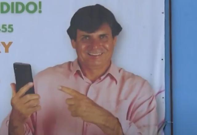 Homem segurando celular e sorrindo