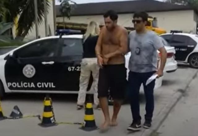 Homem sem camiseta algemado sendo preso pela polícia