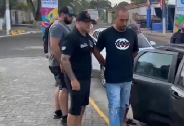 Homem sendo algemado e encaminhado após sair de carro policial