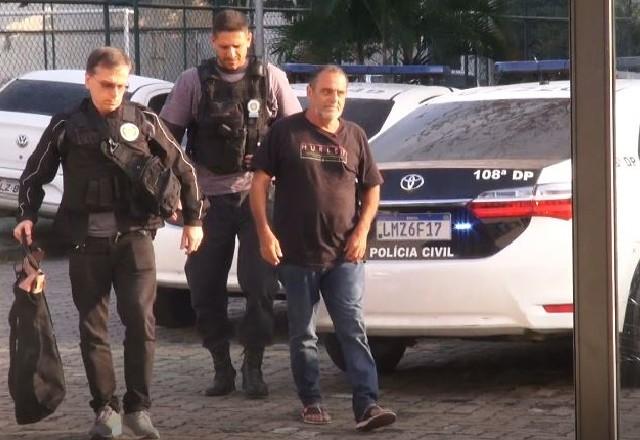 Homem sendo levado por dois policiais