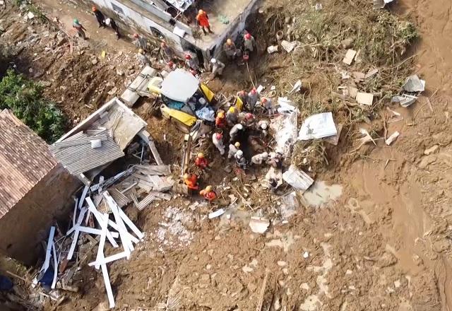 Imagem aérea de área lamacenta, com bombeiros e equipes de resgate realizando buscas