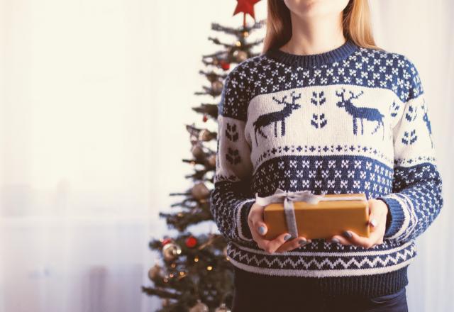Imagem clara com uma mulher segurando um presente de natal