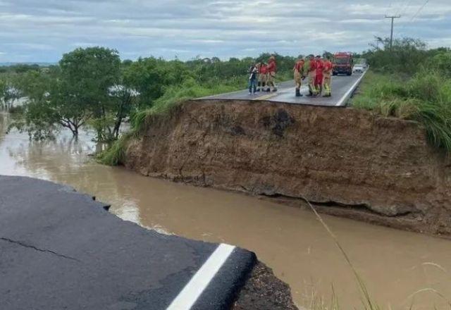 Imagem contém uma ponte danificada e pessoas do Corpo de Bombeiro usando vermelho