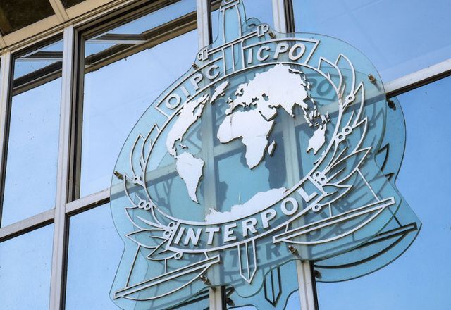 Imagem do logo da Interpol na sede da polícia internacional | Reprodução/Internet