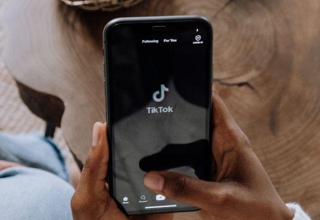 Imagem genérica de uma mulher acessando o aplicativo do TikTok