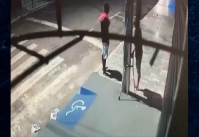 Imagem gravada por câmera de monitoramento mostra o deficiente físico se preparando para escalar o poste (SBT Jonalismo)