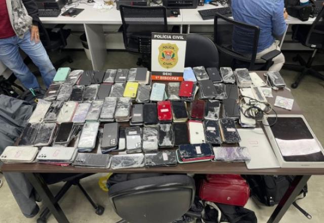 Imagem mostra mesa com mais de duzentos aparelhos celulares roubados que foram apreendidos em uma única operação | Reprodução 
