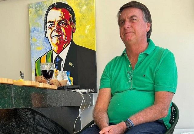 Bolsonaro sentado próximo a quadro com representação sua (Reprodução/Instagram)