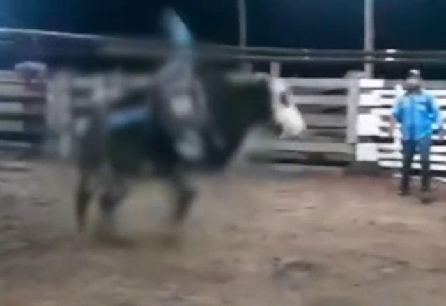 Jovem caindo de boi durante treinamento em arena de rodeio