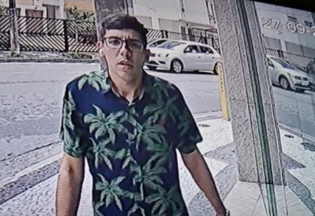Jovem de óculos e camisa preta e verde