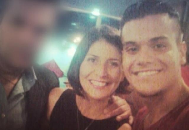 Jovem e mulher brancos, sorrindo para foto, com terceira pessoa desfocada para não identificação