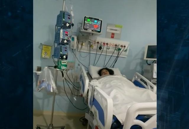 Jovem negra deitada em cama de UTI de hospital