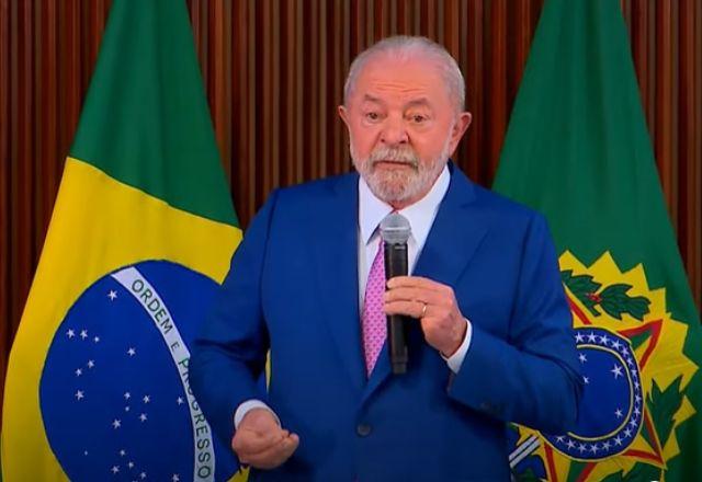 Lula_com_microfone_atras_dele_bandeira_do_brasil