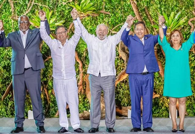 Lula de mãos dadas com outros presidentes, eles estão com os braços erguidos