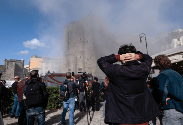 Espectadores observam a poeira subir após o desabamento de partes da Torre dei Conti em Roma, Itália | Reuters/Remo Casilli