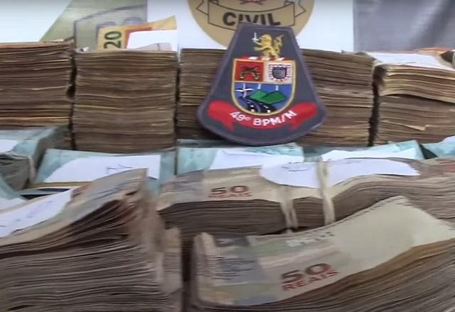 Maços de dinheiro de R$ 50 empilhados em mesa