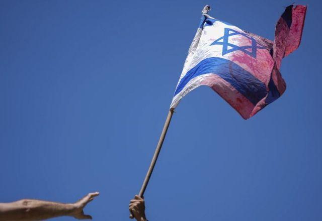 Manifestante balança bandeira de Israel durante protesto contra a reforma do judiciário
