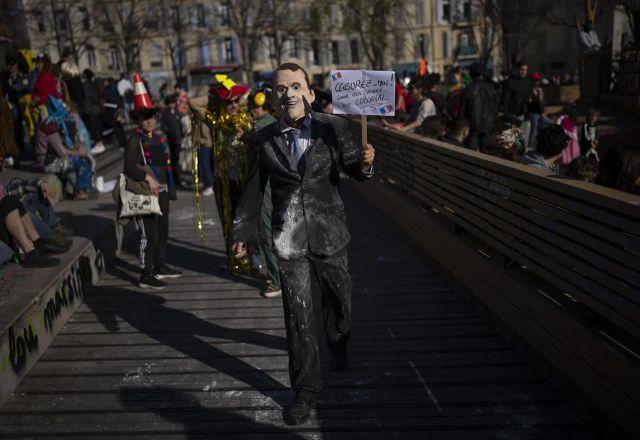 Manifestante usa máscara com cara de Macron