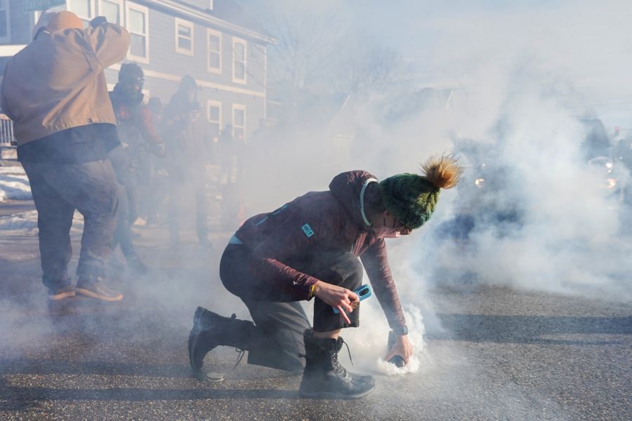 Manifestantes cobre lata de gás lacrimogêneo durante protesto contra agentes de imigração em Minneápolis, nos Estados Unidos | 13/01/2026/Reuters/Ryan Murphy