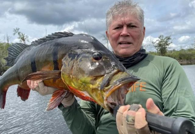 Médico segurando um peixe (Reprodução)