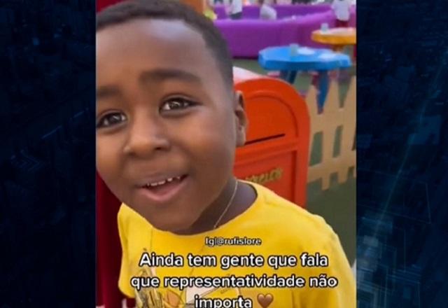 Menino negro sorrindo, de camiseta amarela