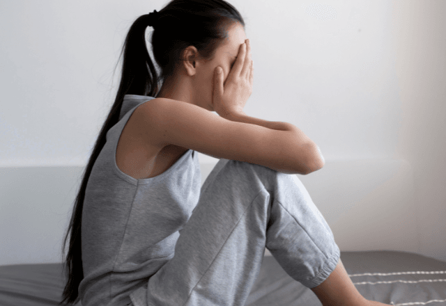 Mulher sentada com as mãos no rosto | Freepik