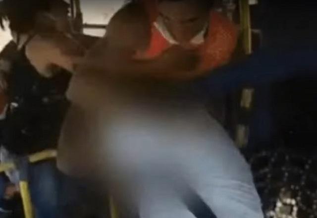 Motorista de ônibus, desfocado para não ser identificado, é agredido por passageiro enquanto mulher tenta contê-lo